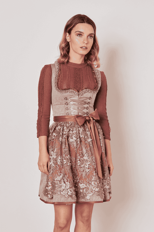 Tradition trifft auf Moderne beim Dirndl Marike. Das taillierte Modell besticht durch sein modernes Design gepaart mit traditionellen Ornamenten. Das Mieder schmiegt sich perfekt an deine Figur an und der Herz-Ausschnitt rückt das Dekolleté ins rechte Licht. Für kleine Habseligkeiten bietet der Rock zwei Eingrifftaschen. Der 50cm lange Rock