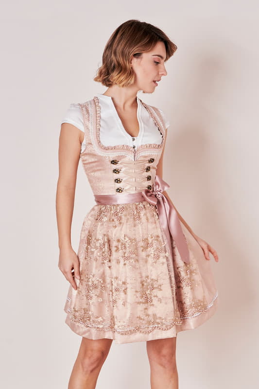 Das Dirndl Kailia ist durch die Perlenschürze ein wahrer Blickfang! Das Dirndlkleid wird von einem romantischen Ornamenten-Muster geschmückt. Zarte Borten und Herz-Miederhaken zieren das Mieder.