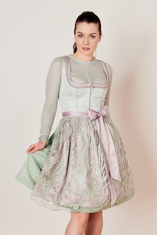 Das Dirndl Celestina geht Hand in Hand mit Tradition und Moderne. Die hochwertig bestickte Paillettenschürze ist zweilagig hebt damit die Stickereien besonders hervor und sorgt nebenbei für einen modernen Look. Das eigentliche Highlight ist jedoch die Komposition aus schlichtem Dirndlkleid und üppiger Schürze. Das verleiht unserem Dirndl einen stilvollen Auftritt und sorgt für das gewisse Etwas. Das An- und Ausziehen wird durch den Reißverschluss zum Kinderspiel. Mit dem Dirndl Celestina aus der COLLECTION-Kollektion bringst du frischen Wind in deine Trachtengarderobe.