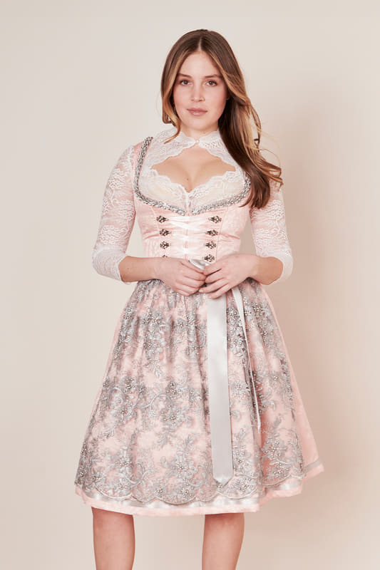 Das romantische Dirndl Amara in einem schönen Farbspiel. Das Dirndl Amara ist durch die bestickte Perlenschürze ein wahrer Hingucker! Das Dirndlkleid wird von einem romatischen Muster zart geschmückt. Die zwei Eingrifftaschen im Rock bieten praktischen Stauraum