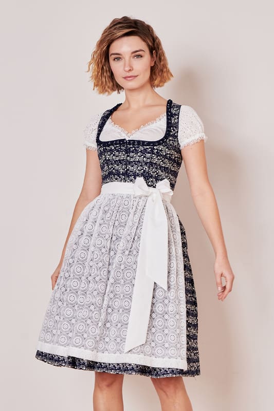 Mit unserem Dirndl Minna stichst du auf jedem Fest hervor! Das schöne Allover-Ornamentmuster harmoniert perfekt zur zarten Spitzenschürze. Es ist tailliert geschnitten