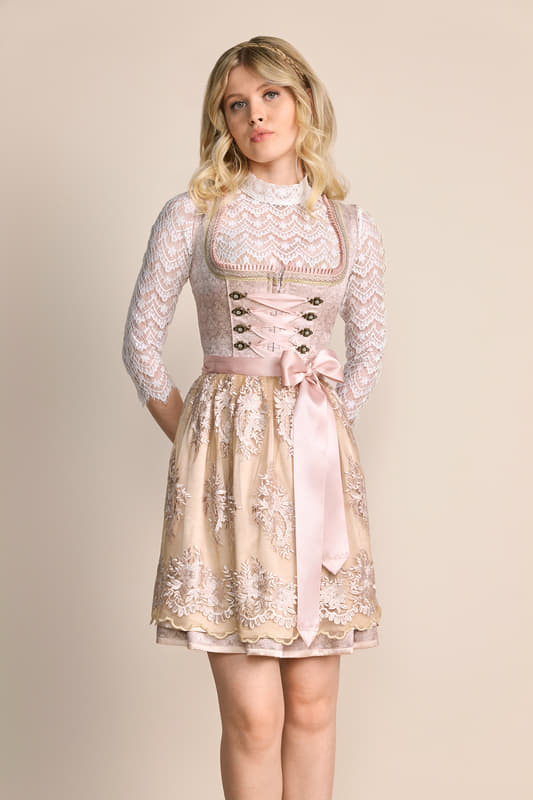 Das Dirndl Lunie verbindet modernen Stil mit traditionellen Elementen. Das hübsche Streublumenmuster und die bestickte Schürze sind ein echter Hingucker. Dank der taillierten Passform schmeichelt das Dirndl deiner Figur