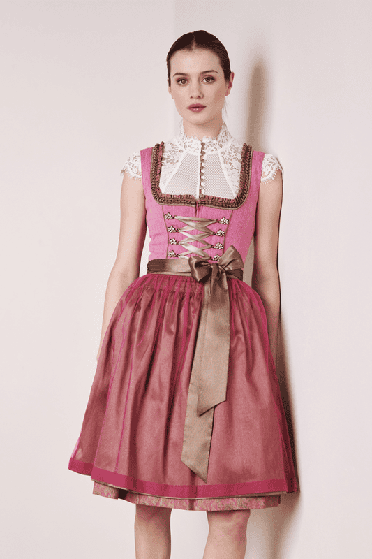 Das edle Dirndl Fuchsia überzeugt mit seiner tollen doppellagigen Schürze auf dem gemusterten Rock. Die dreistufige Borte umspielt das Dekollelté und setzt dem ganzen die Krone auf.