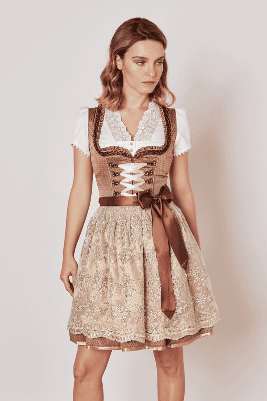 Erlebe traditionelle Mode neu interpretiert mit dem modernen Dirndl Pamina. Dieses taillierte Dirndl schmeichelt deiner Figur und setzt sie durch die Miederschnürung perfekt in Szene. Mit seinem ornamentalen Muster auf dem Rock und dem herzförmigen Ausschnitt ziehst du alle Blicke auf dich. Die Rocklänge von 50cm endet charmant über dem Knie. Praktische Eingrifftaschen im Rock und ein vorderseitiger Reißverschluss sorgen für Funktionalität. Als Highlight verzaubert die bestickte Perlenschürze mit ihrer Detailverliebtheit. Ob auf dem Oktoberfest oder anderen Festivitäten