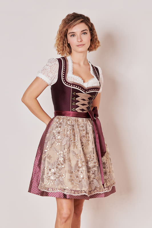 Erlebe den traditionellen Stil des Dirndls Fernanda (50cm) aus der MADL Kollektion. Dieses taillierte Modell mit Herz-Ausschnitt und ärmellosem Design liegt mit seinem Look voll im Trend. Das Ornamentmuster auf dem Rock und der bestickten Perlenschürze verleihen dem Dirndl einen edlen Look. Zwei Eingriffstaschen im Rock sorgen für praktischen Stauraum. Der vordere Reißverschluss ermöglicht ein einfaches An- und Ausziehen. Die Rocklänge von 50cm lässt das Dirndl leicht über das Knie fallen und wirkt spielerisch zugleich. Die Schnürung am Mieder rundet den Look ab. Trage dieses Dirndl und genieße den Komfort und das stilvolle Design.