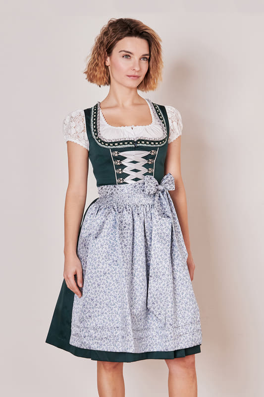 Entdecke das klassische Dirndl Rieke (60cm). Es verbindet modernen Stil und traditionelle Eleganz. Das unifarbene Mieder mit geradem Ausschnitt schmeichelt deiner Figur