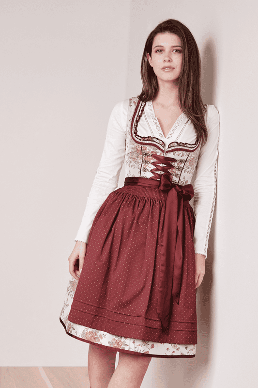 Das Dirndl Monja kommt mit einem schönen Blumenmuster entlang des Dirndlkleides. Die gepunktete Dirndlschürze harmoniert perfekt mit der Miederschnürung und den zahlreichen Borten entlang des Dekolletés.